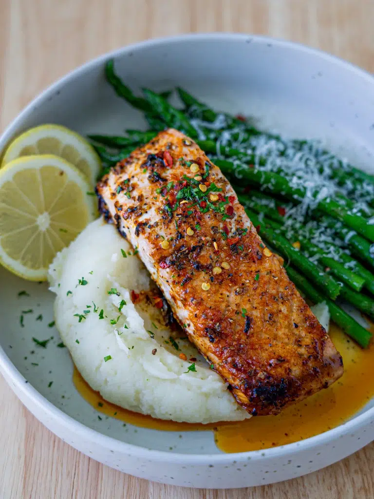 side view of plated salmon with mashed potato and asparagus