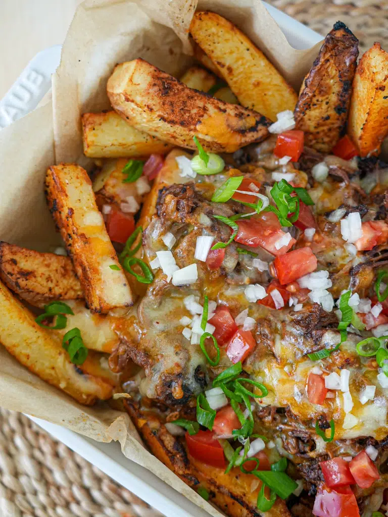 Close-up of Beef Brisket Loaded Fries with crispy fries, slow-cooked beef brisket, and melted cheese.
