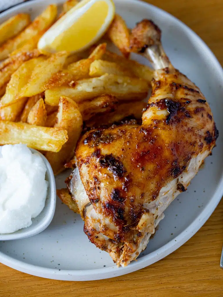 Side view of Portuguese chicken served with crispy oven-baked chips