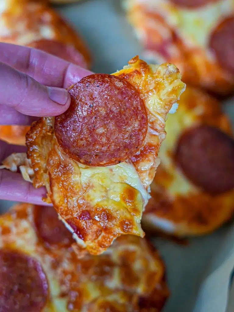 Close-up of a half-cut mini pizza, showcasing its delicious toppings and golden crust.